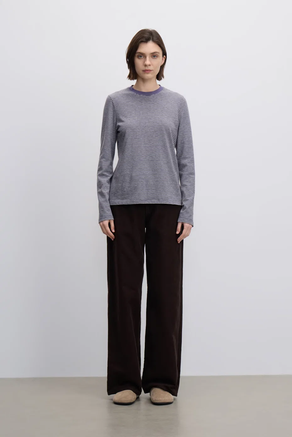 Grey striped long-sleeve top with dark-brown trousers.
