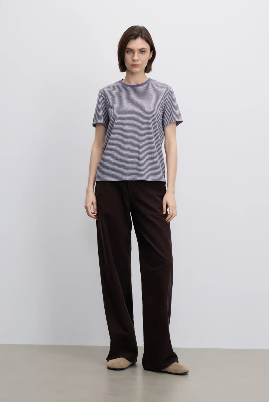 Grey striped short-sleeve top with relaxed brown trousers.