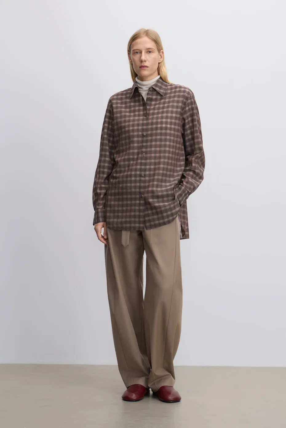 Brown-check overshirt with relaxed taupe trousers.