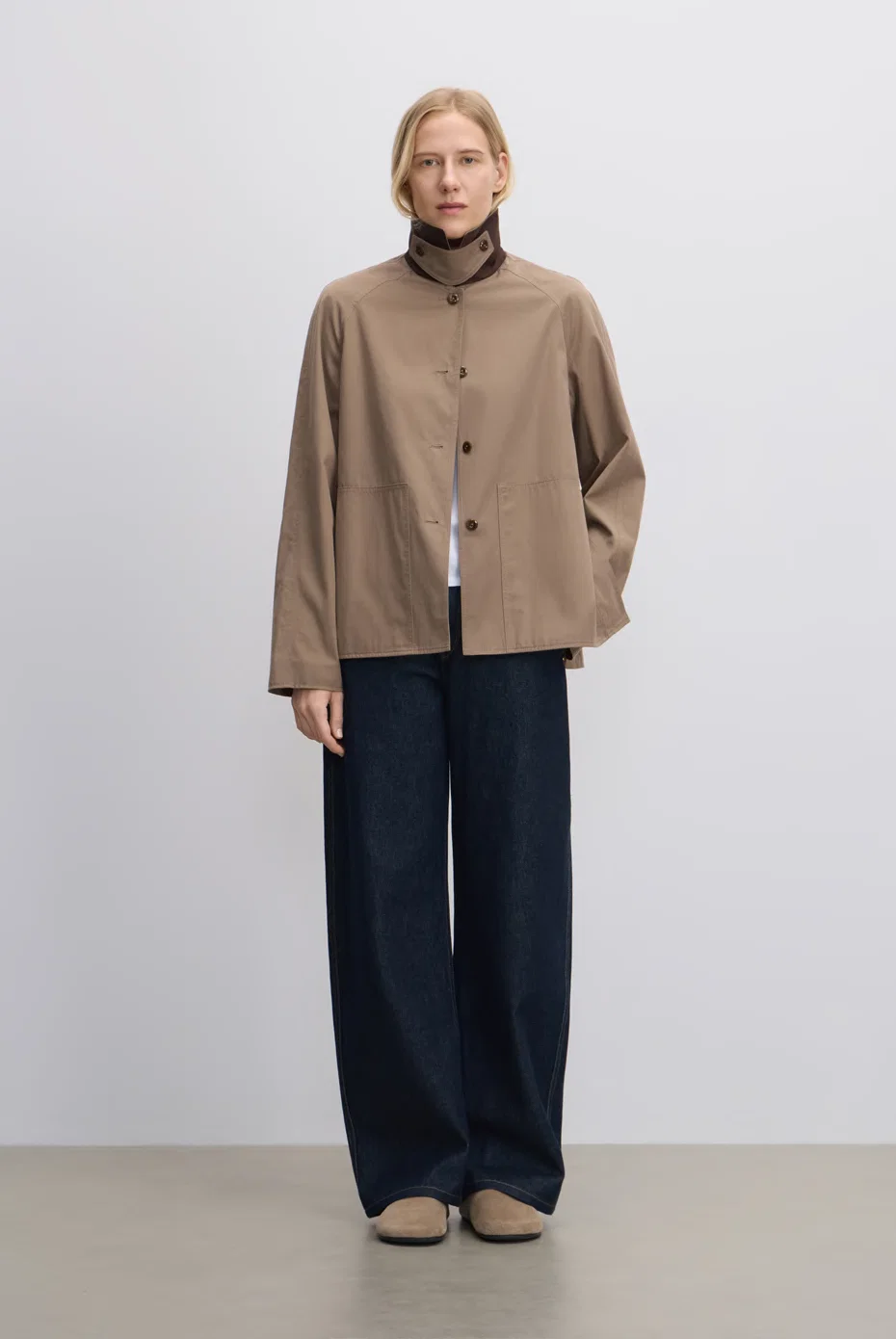 Tan collared jacket with dark navy wide-leg trousers.