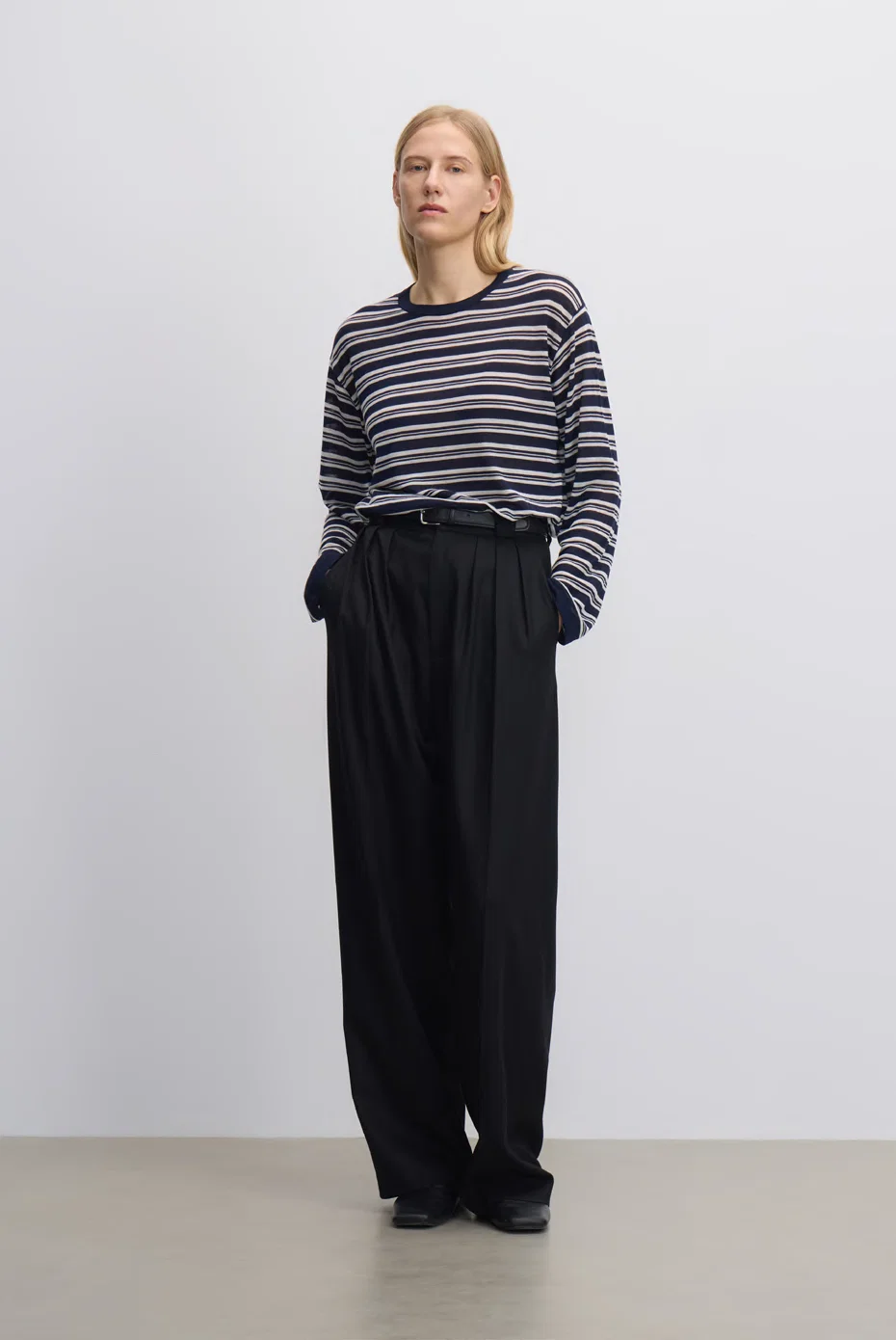 Black-and-grey striped knit with black wide-leg trousers.