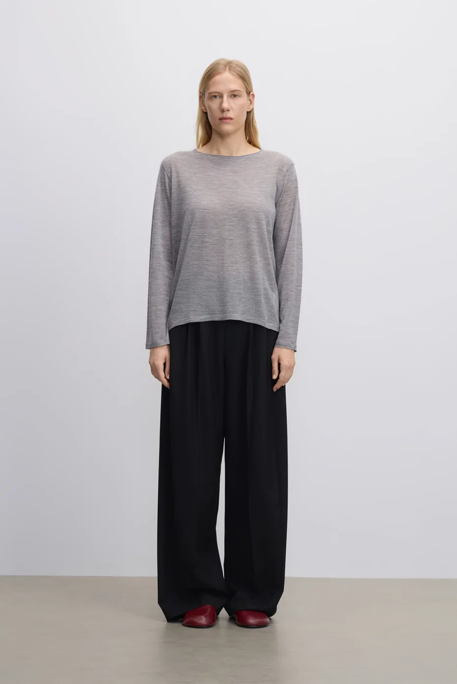 Light-grey long-sleeve top with fluid black trousers.