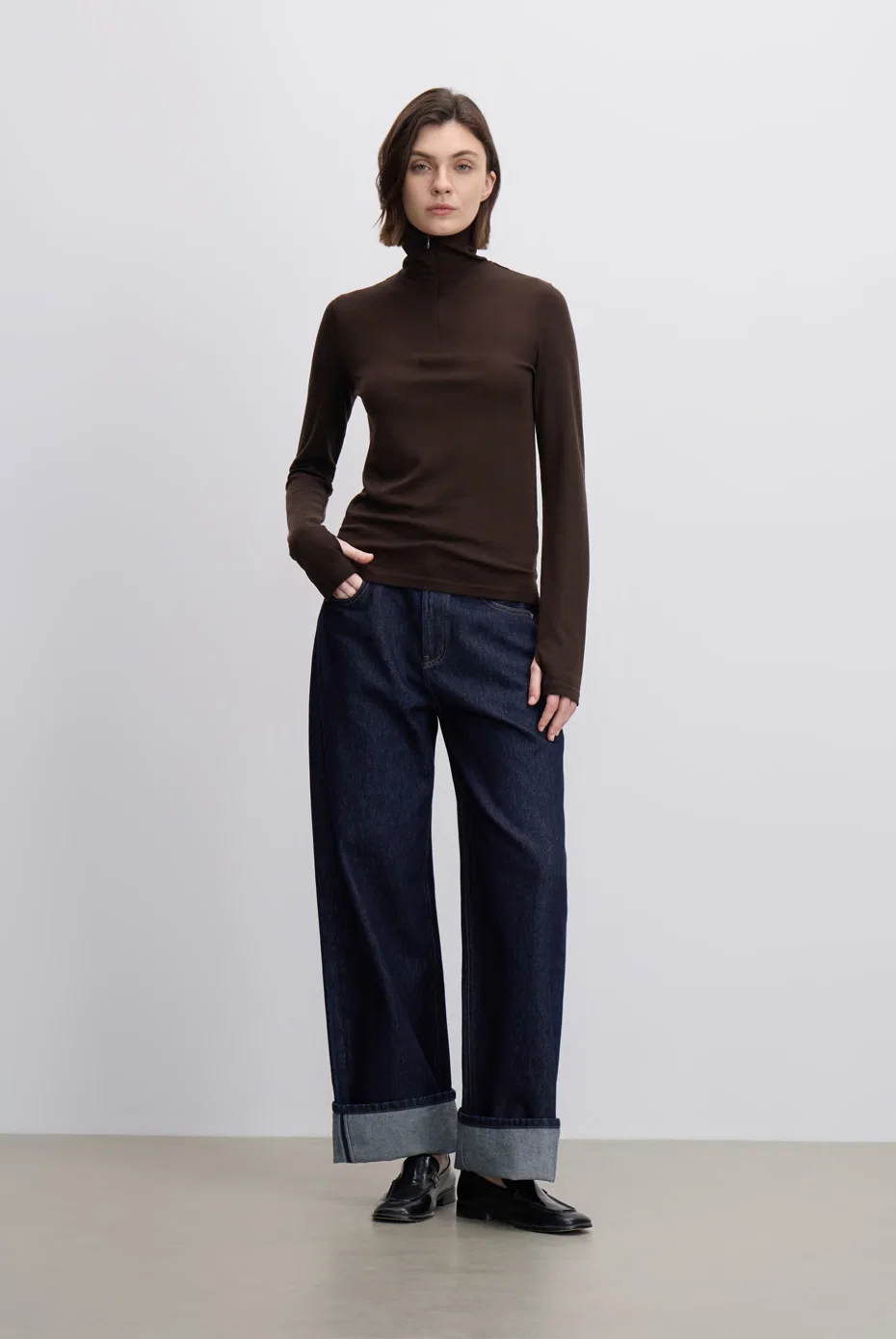 Brown turtleneck knit with cropped indigo jeans.