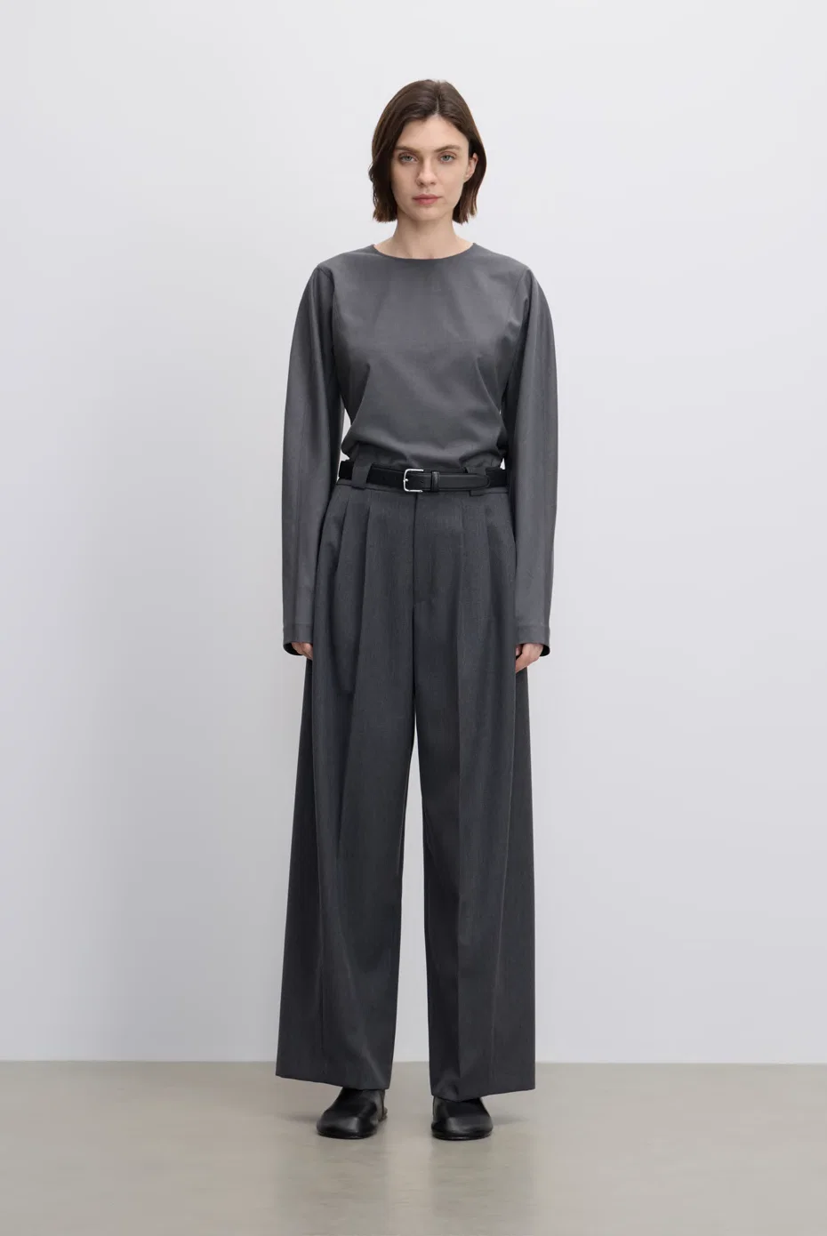 Grey long-sleeve top with belted grey wide-leg trousers.