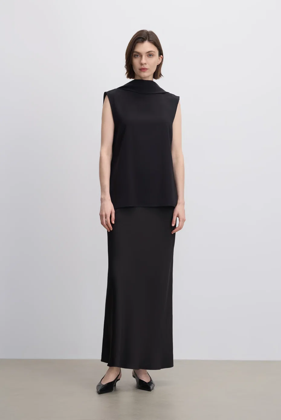 Sleeveless black high-neck maxi dress in a straight silhouette.