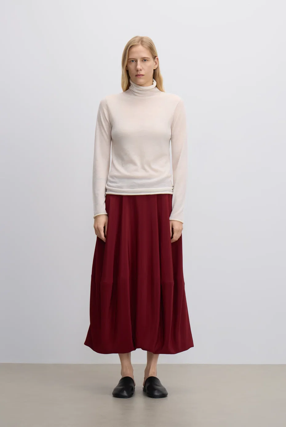 Pale knit with a deep-red midi skirt.