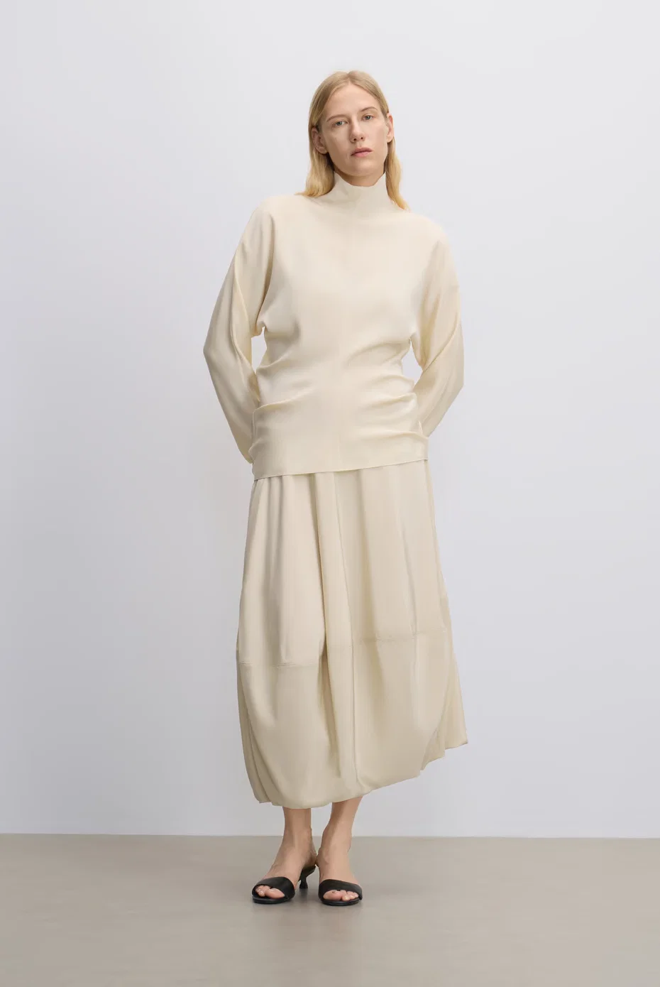 Ivory turtleneck knit with a tonal voluminous skirt.