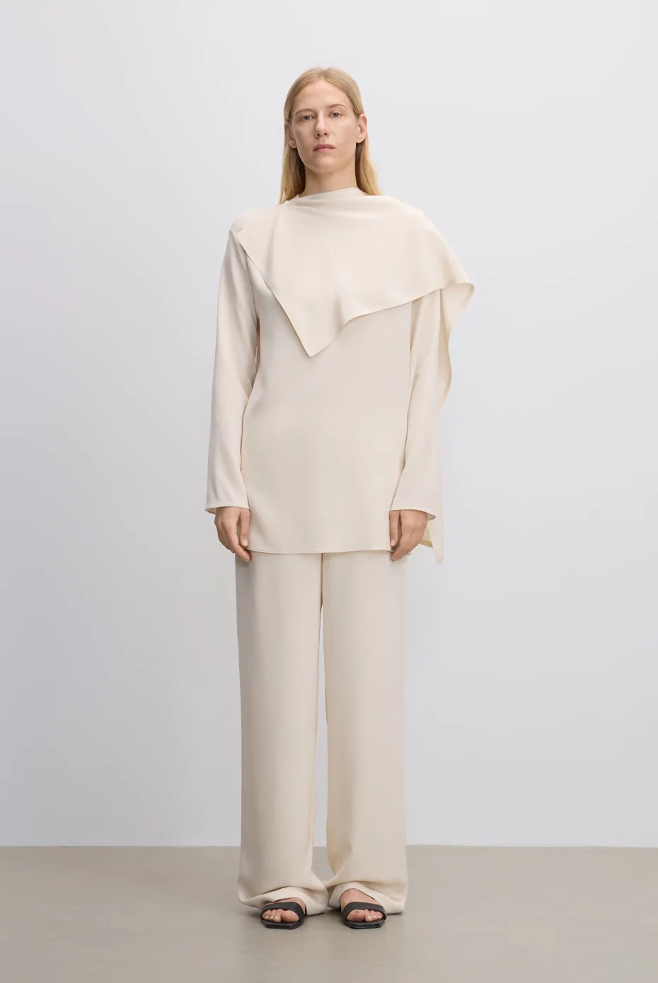 Ivory asymmetrically draped knit with tonal trousers.