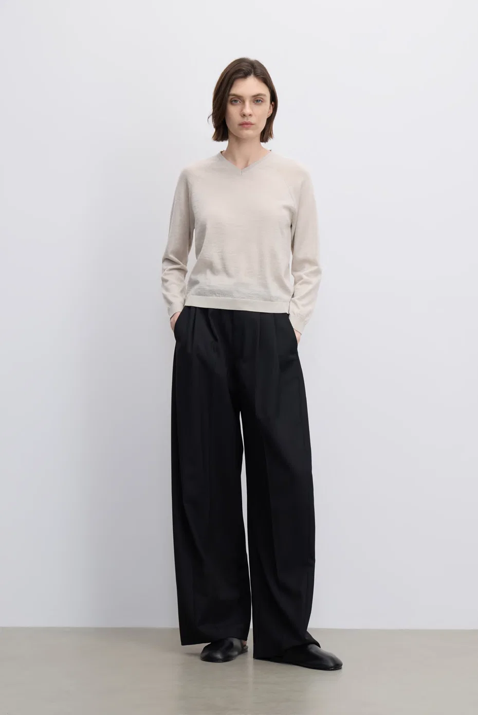 Pale-grey sweater with fluid black trousers.