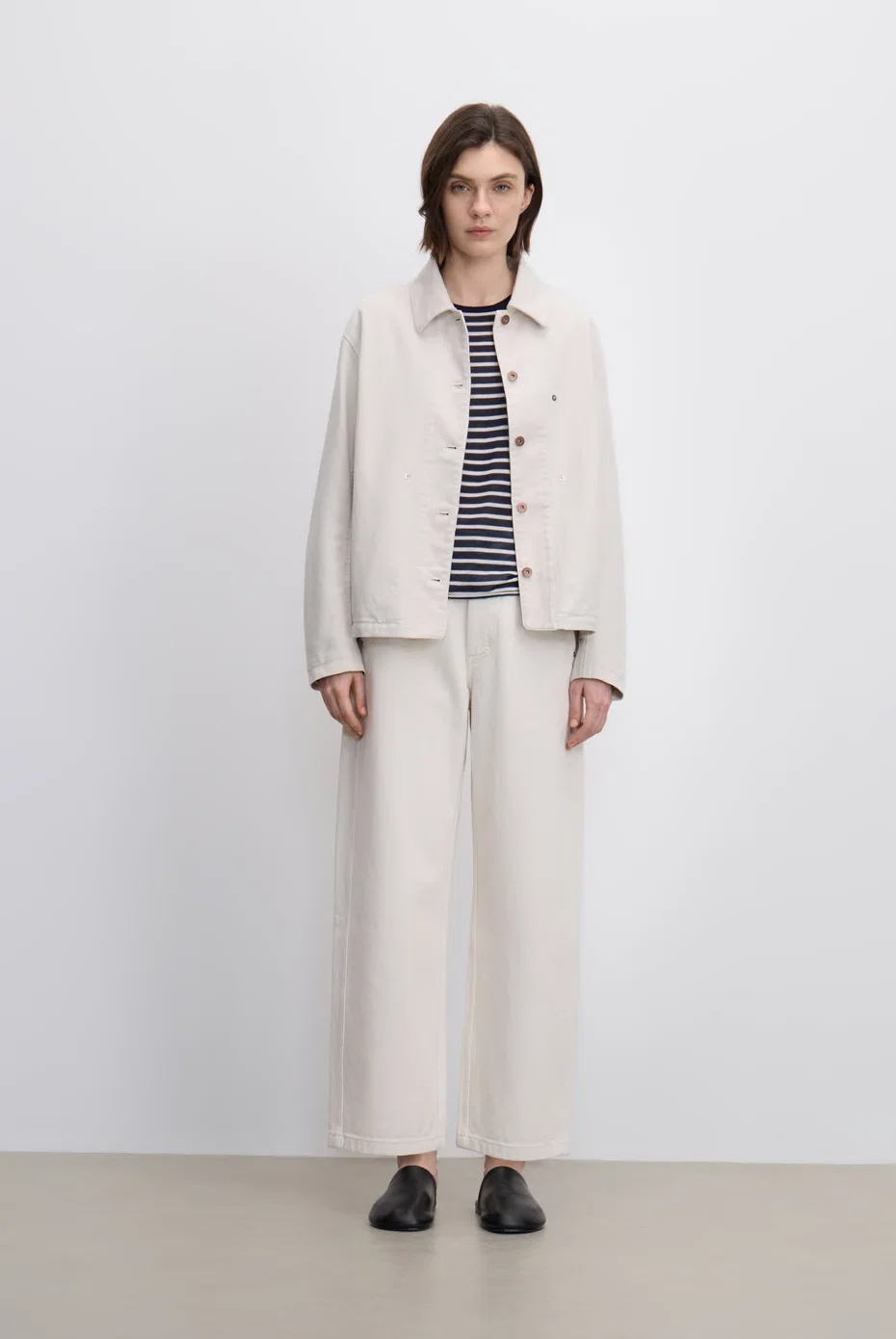 Ivory jacket over a striped knit with tonal floor-length bottoms.