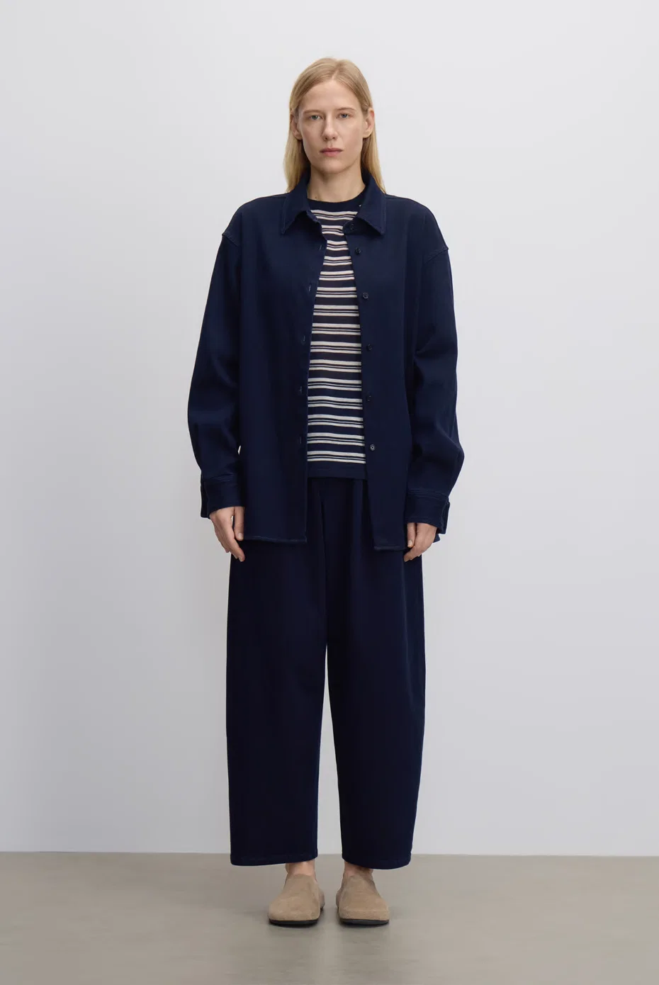 Navy jacket over a striped knit with navy cropped trousers.