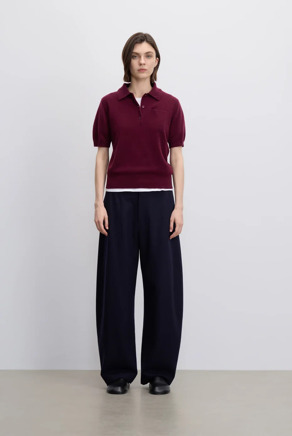Burgundy polo knit with navy wide-leg trousers.