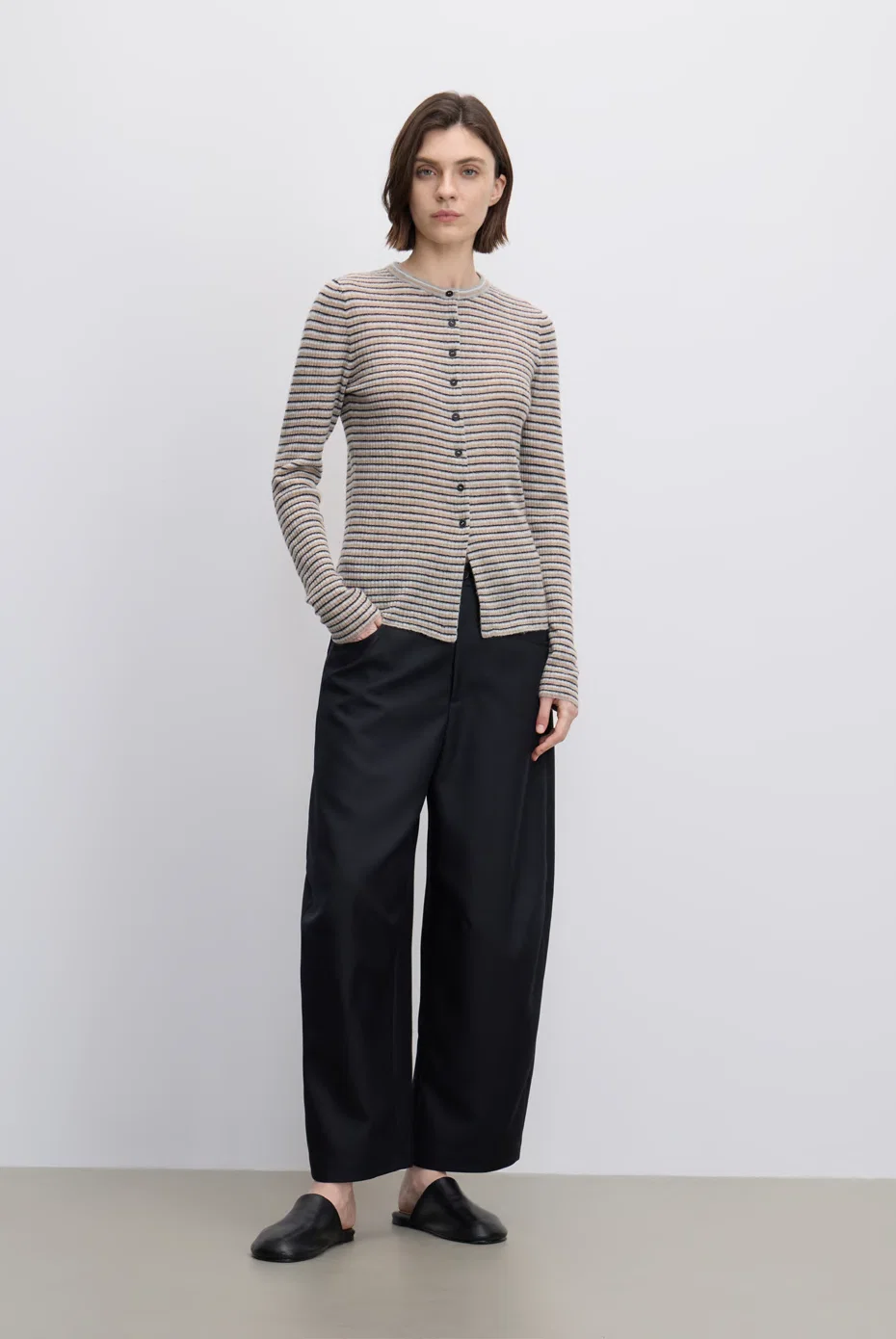 Taupe ruched cardigan with black trousers.