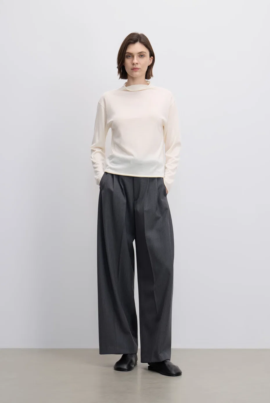 Ivory sweater with black wide-leg trousers.