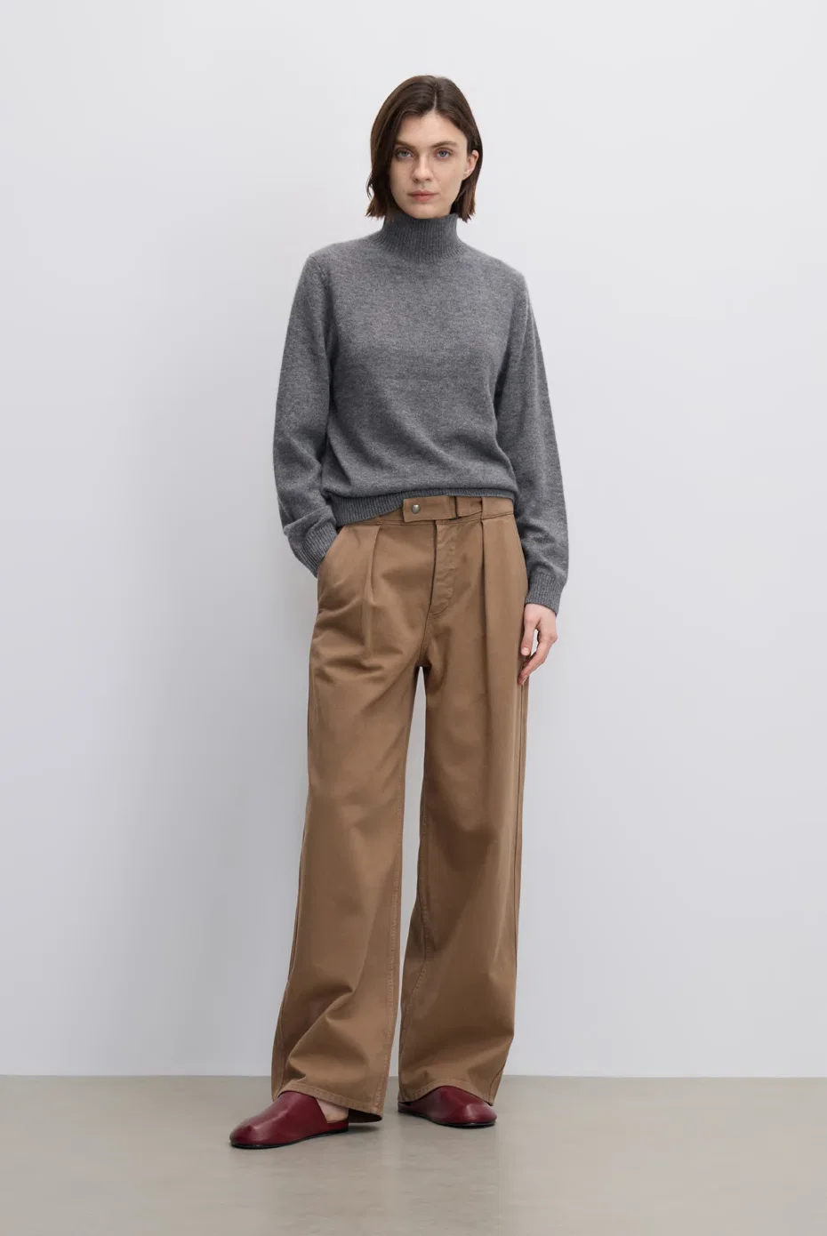 Grey turtleneck top with camel wide-leg trousers.
