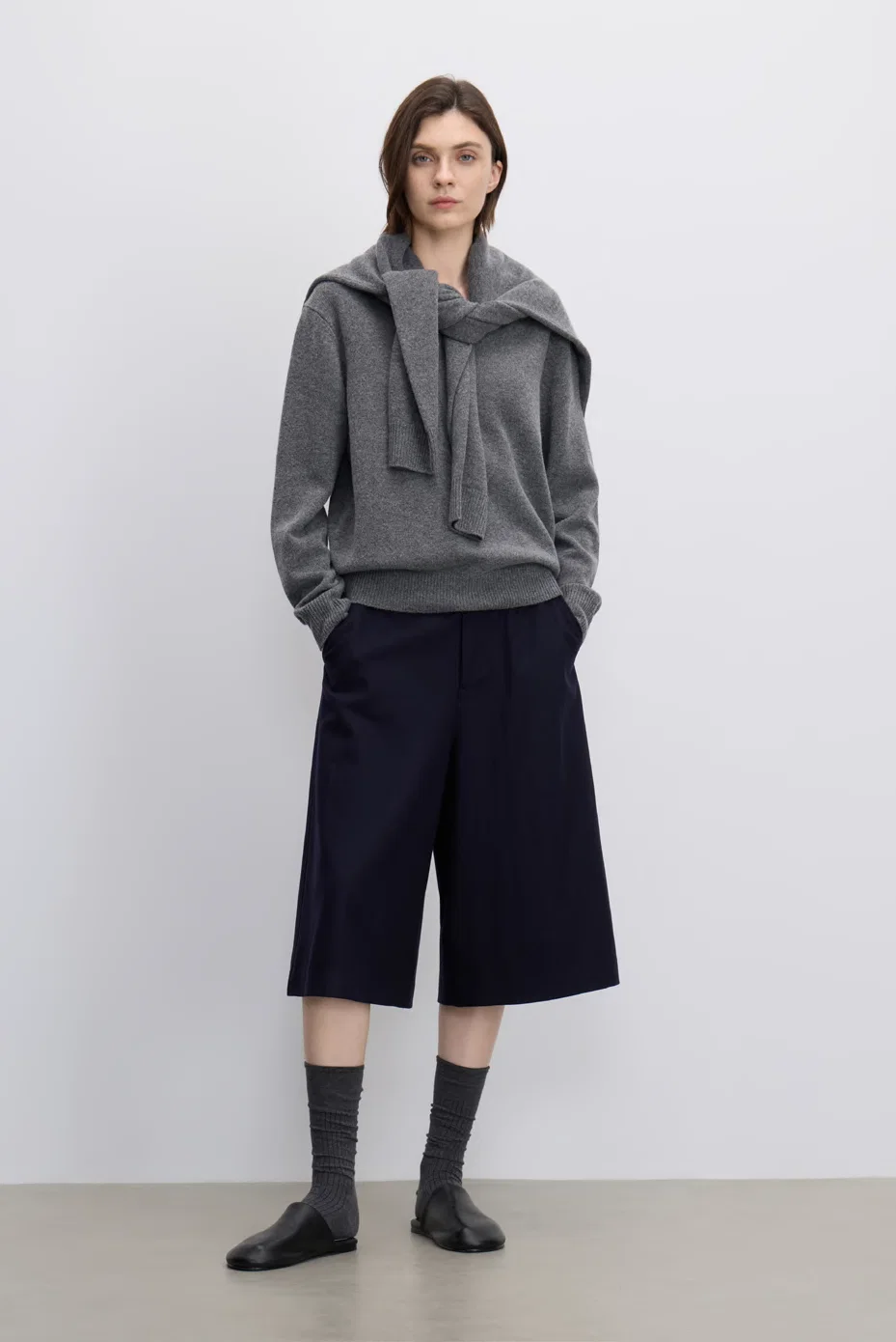 Grey jacket with navy Bermuda shorts.